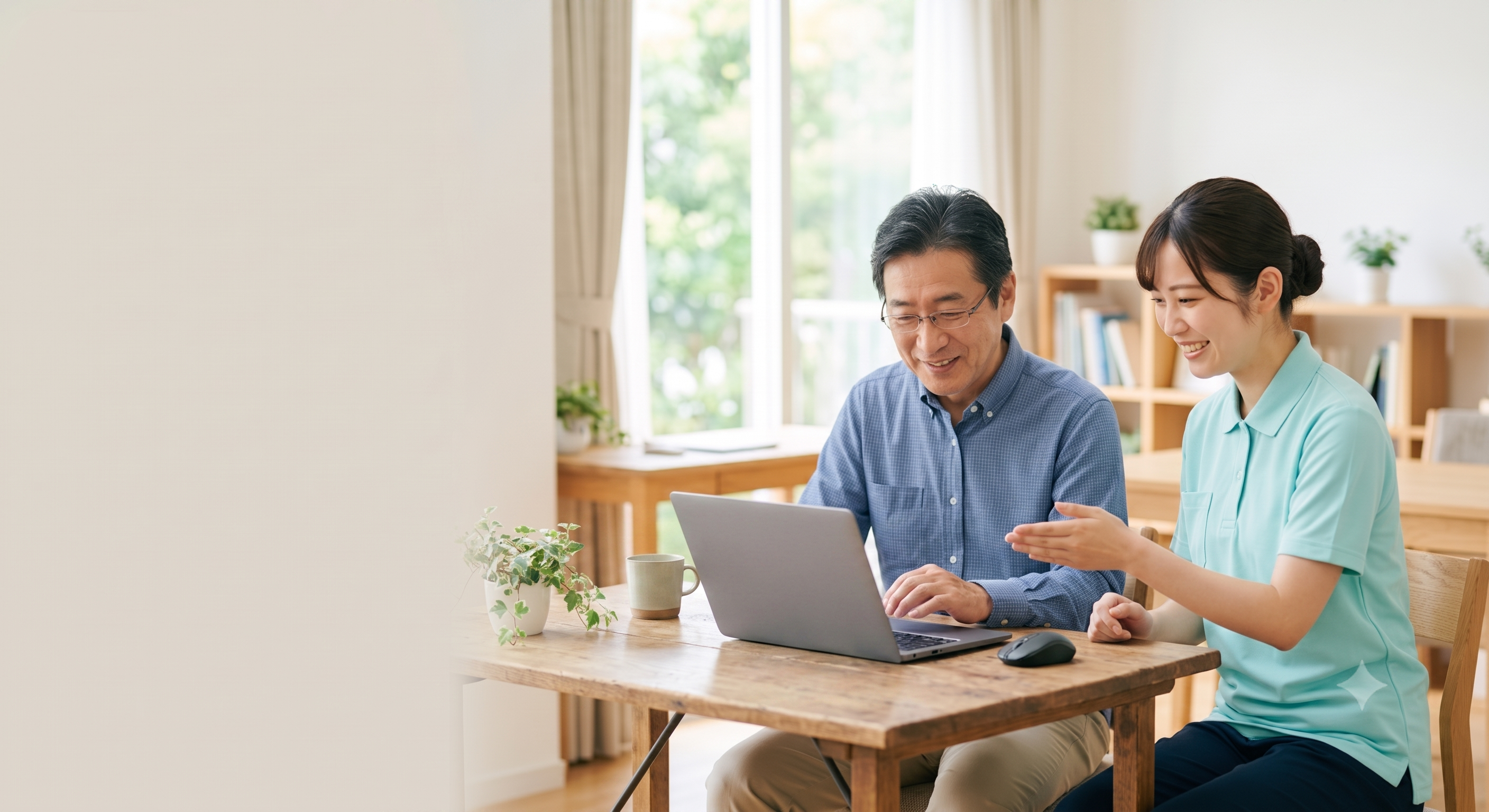 ノートパソコンの画面を見ながら話す介護スタッフと利用者